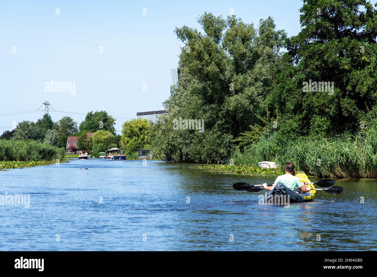 Oud-Alblas, Paesi Bassi-Luglio 2021; Vista sul fiume Oud Alblas con persone in canoa gonfiabile e altre barche da diporto godendo di una d estate Foto Stock