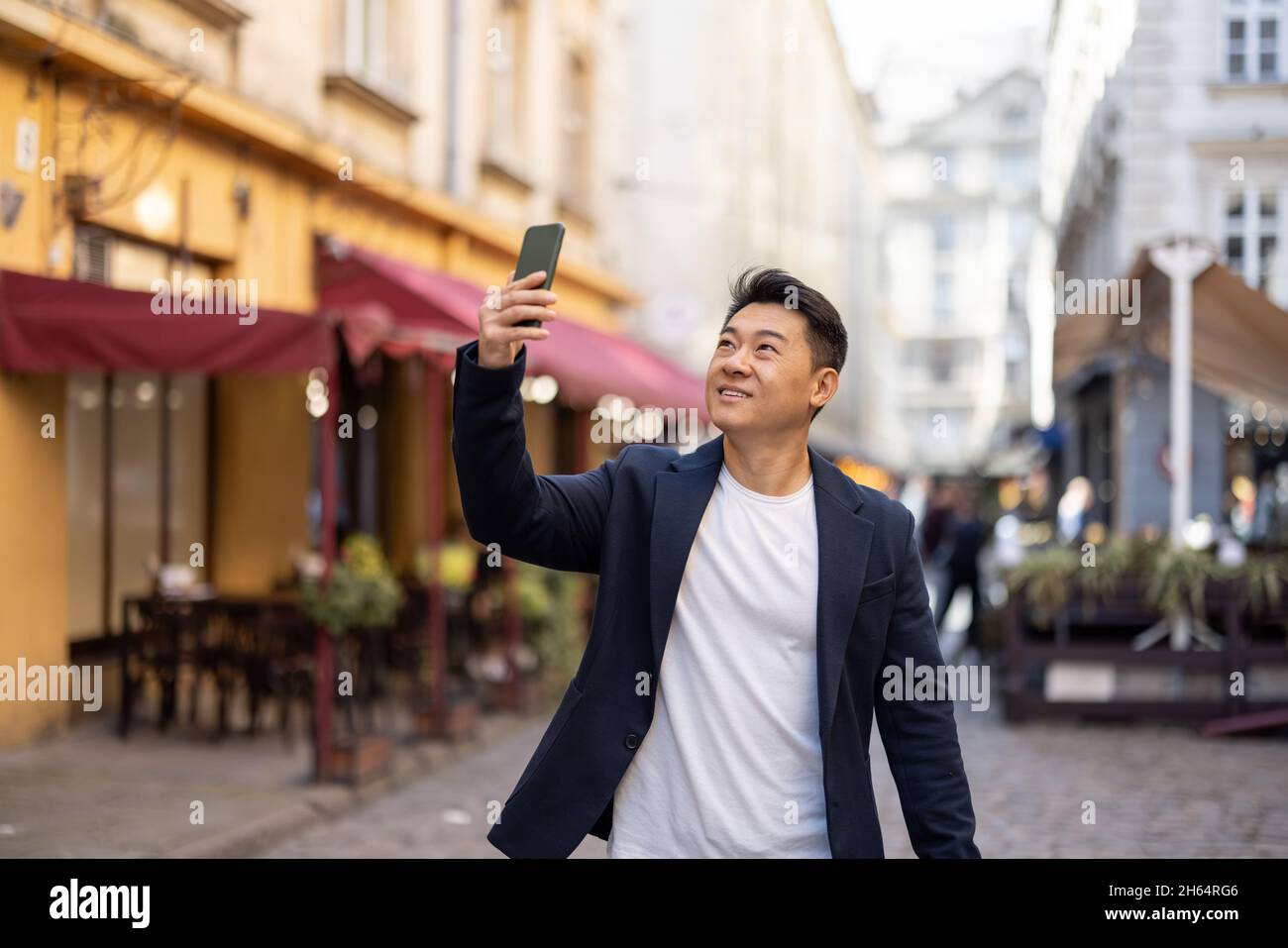 Uomo d'affari con telefono nella strada della città vecchia Foto Stock