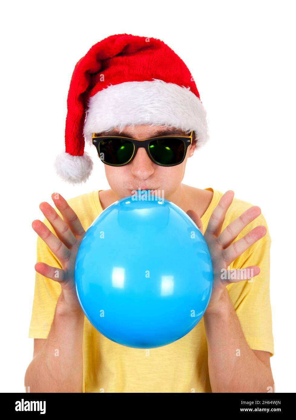 Giovane uomo a Santa Hat gonfiare una palloncino blu isolato sullo sfondo bianco Foto Stock