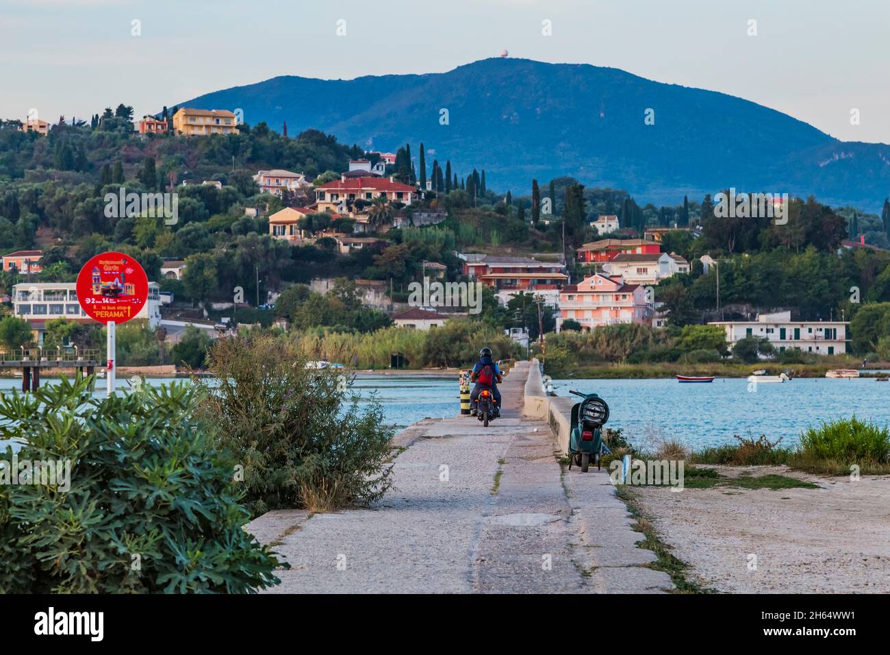 Ammira lo stretto molo di cemento lungo a Kanoni Corfu Grecia, che collega Kanoni e Perama, il luogo ideale per avvistare. Gli aerei stanno atterrando a destra abo Foto Stock