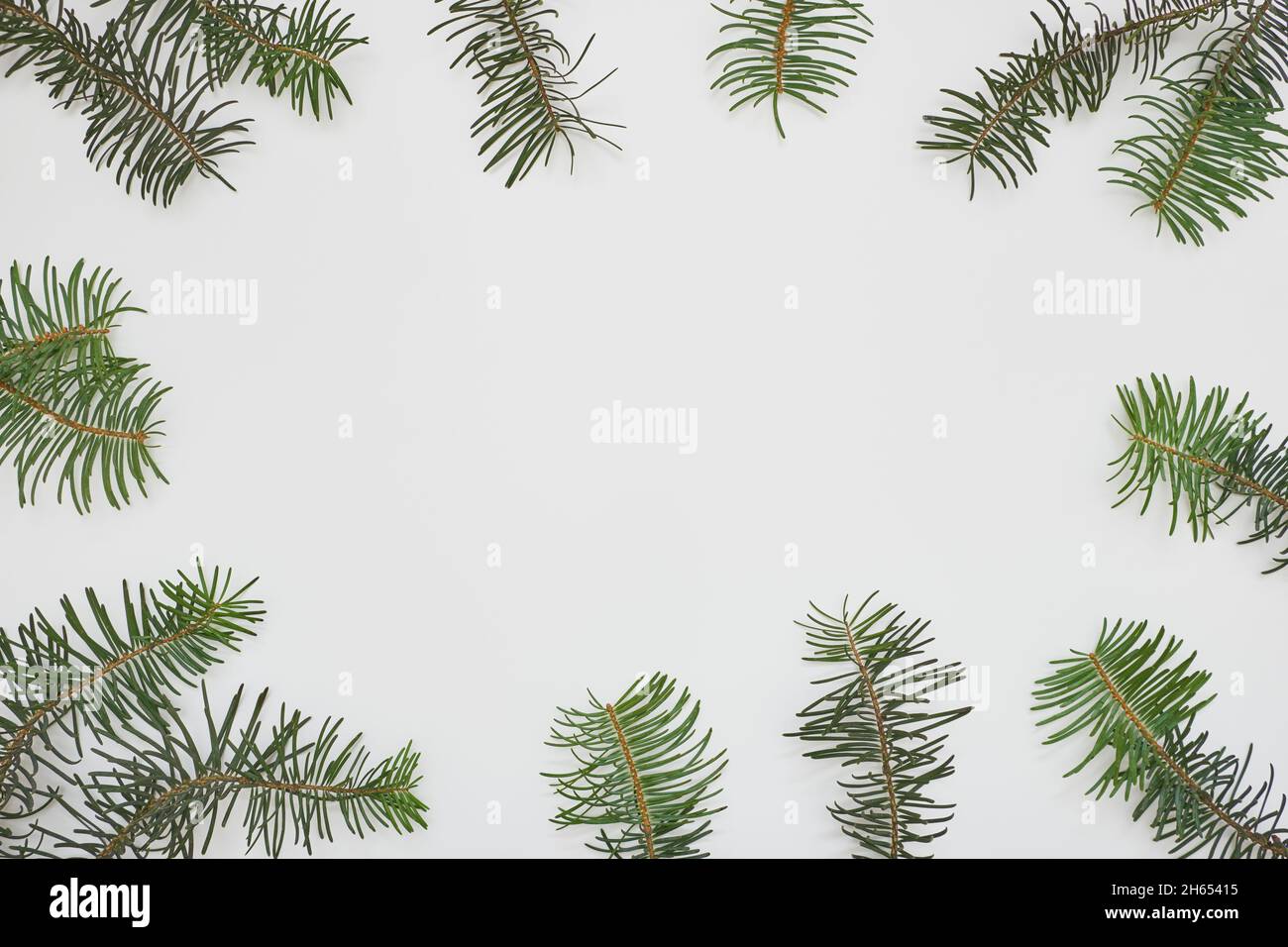 Composizione di Natale o Capodanno. Cornice in rami di abete verde su sfondo bianco. Disposizione piatta, vista dall'alto, spazio di copia. Foto Stock