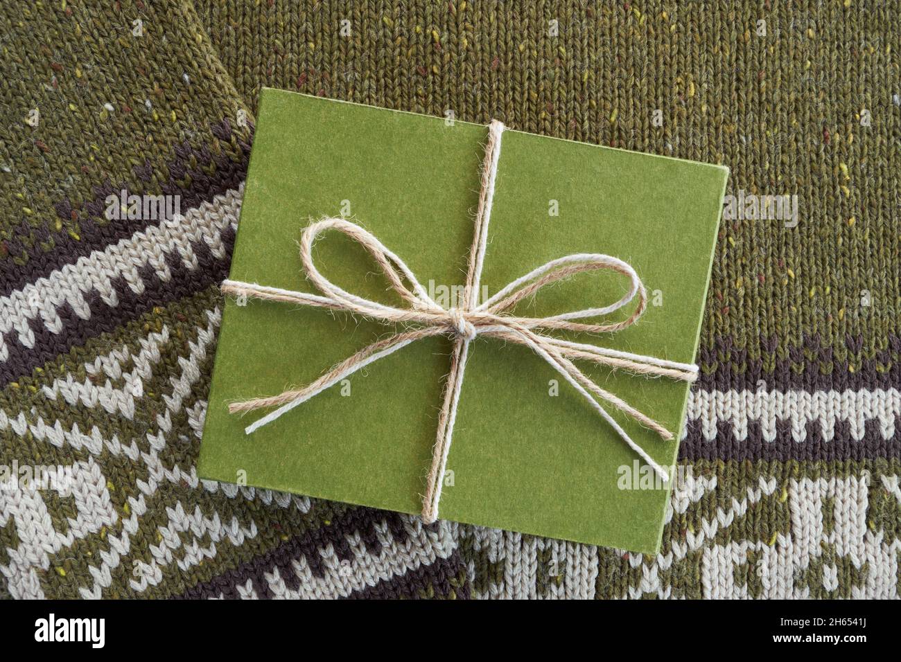 Confezione regalo in cartone verde su sfondo di lana lavorato a maglia Foto Stock