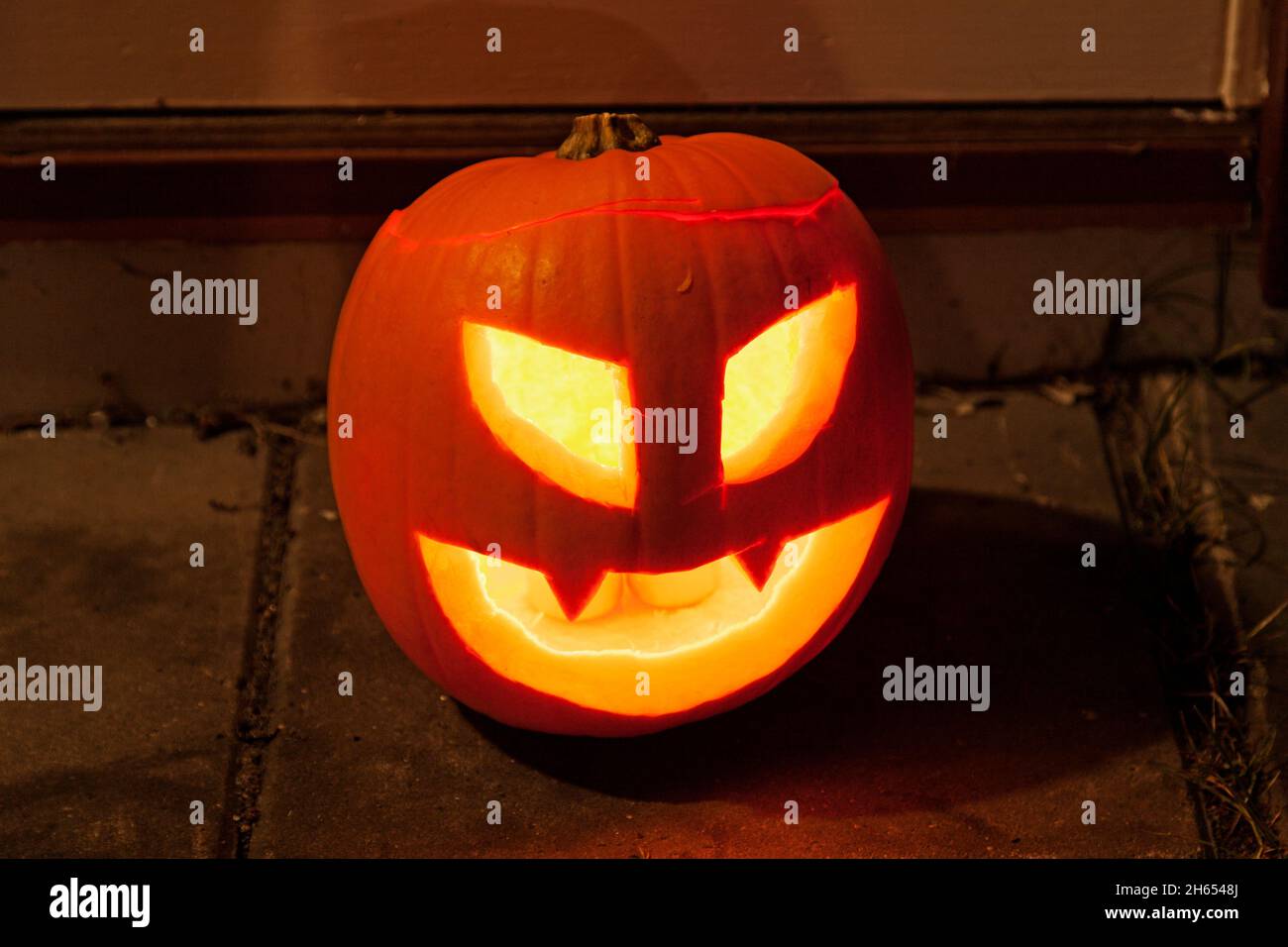 Classica zucca per Halloween che si alza a terra e brilla con tealights Foto Stock