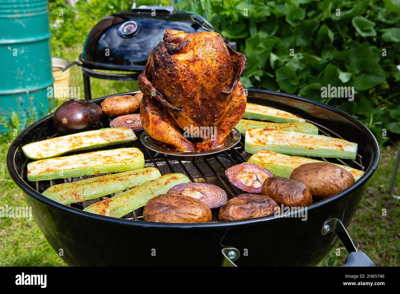 Carcassa di pollo e verdure cotte e affumicate su una griglia a carbone Foto Stock