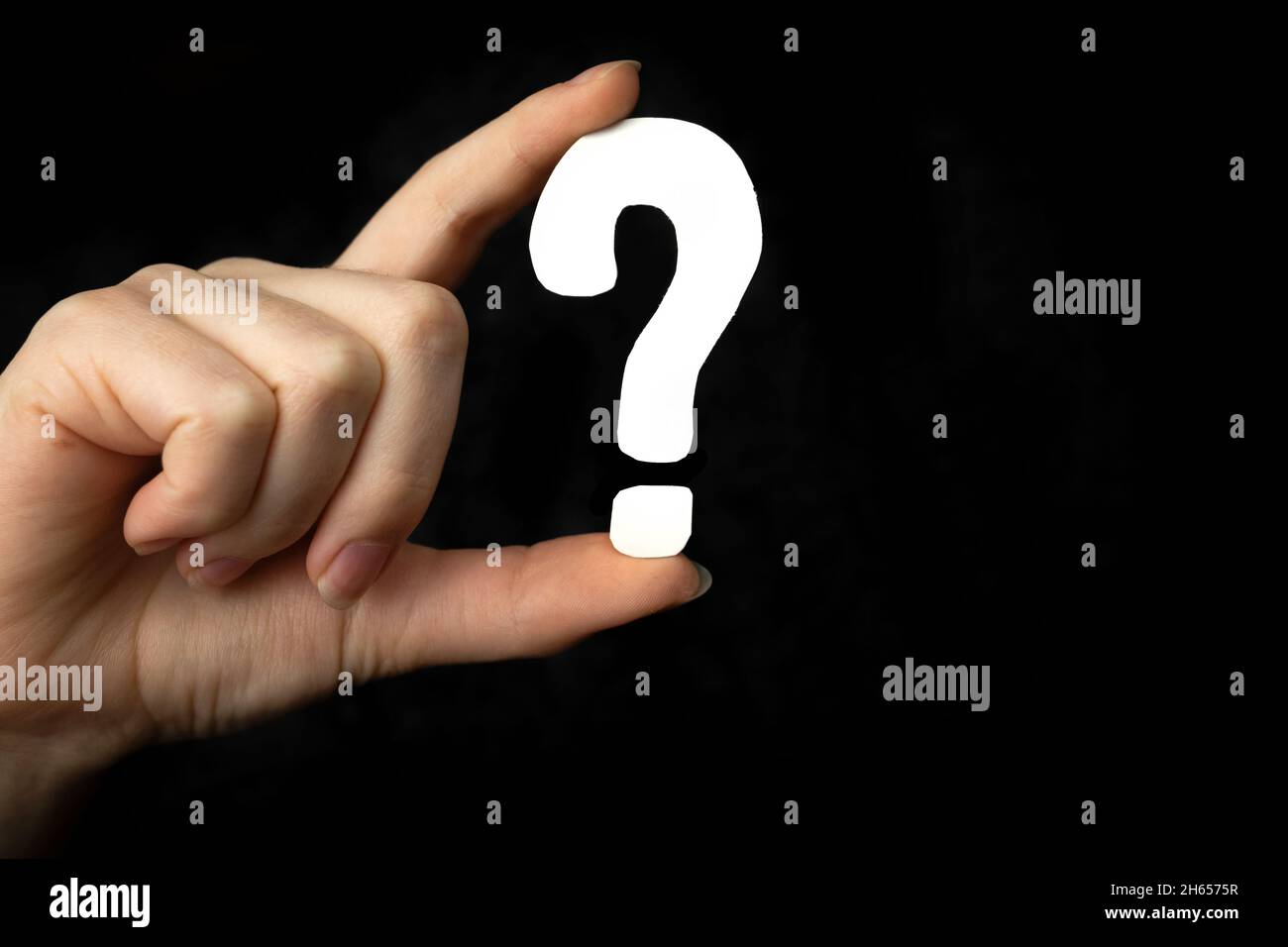 Segno del punto interrogativo in mano. Icona domanda, simbolo su sfondo nero. Concetto di dubbio, istruzione o FAQ Foto Stock