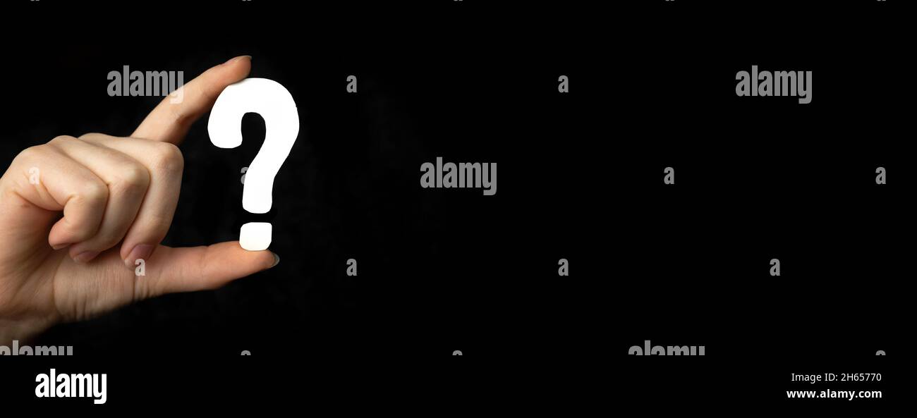 Segno del punto interrogativo del banner in mano. Icona domanda, simbolo su una foto di sfondo nera Foto Stock