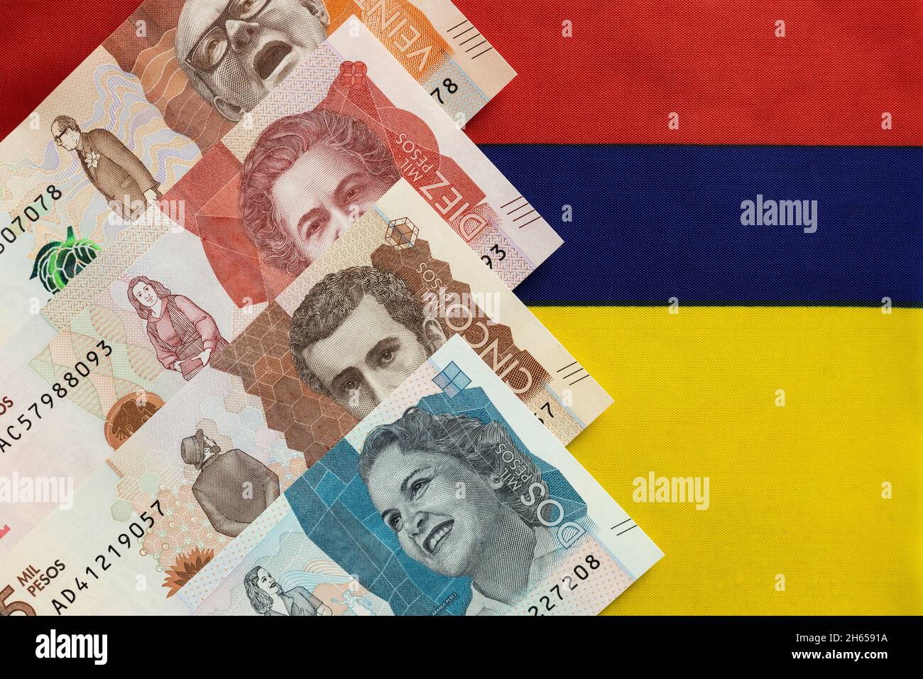 Denaro colombiano, banconote in pesos sullo sfondo della bandiera nazionale della Colombia Foto Stock