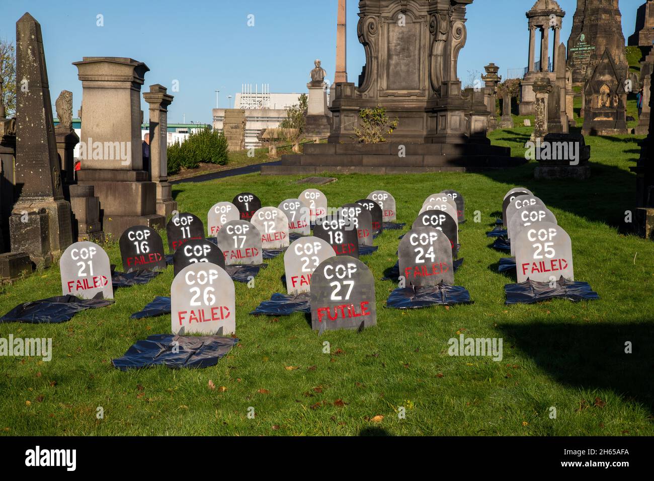 La Brigata Red Rebel si unisce alla Brigata Blue Rebel nel cimitero della necropoli di Glasgow per il funerario del COP26. Gli attivisti del clima piangente sentono che il COP26 è un fallimento e hanno organizzato un funerale fittizio per il vertice. COP26 è posto a riposo in una tomba accanto a tutti i vertici precedenti della COP.COP27 è etichettato come inutile. Foto Stock