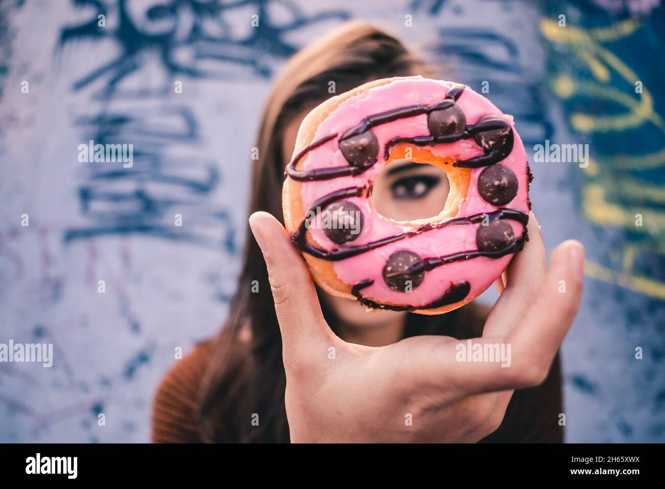 Ragazza bianca con pattinatore ispanico e ciambella al skate Park Foto Stock