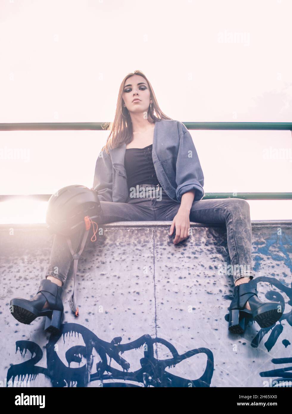 Bella bruna ispanica al skate Park in jeans e giacca jean Foto Stock