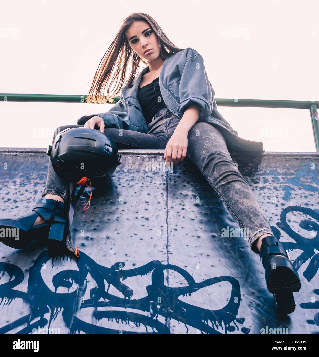 Bella bruna ispanica al skate Park in jeans e giacca jean Foto Stock
