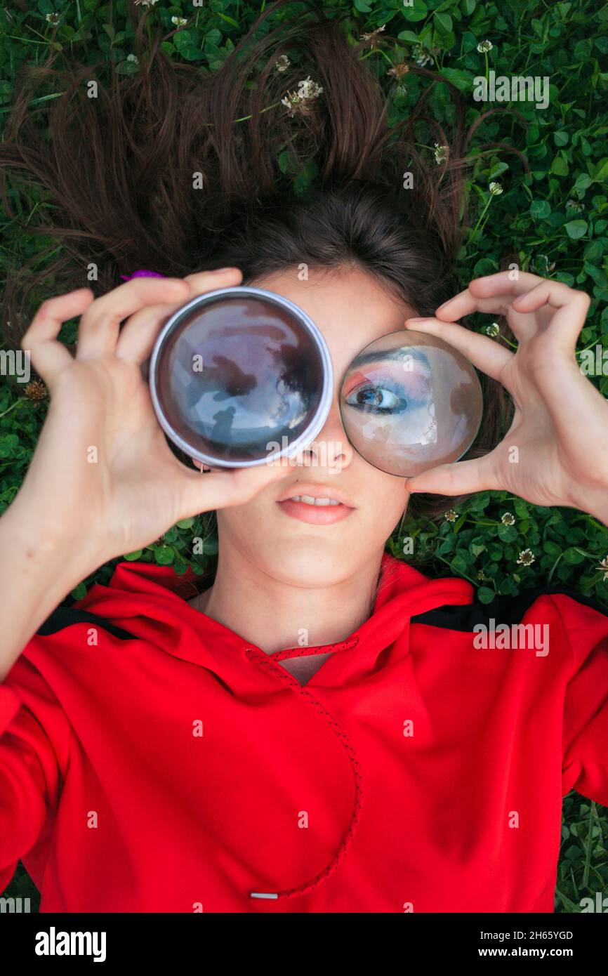 Bella modella femminile si posa in erba fiorita bianca e chiodi di garofano Foto Stock