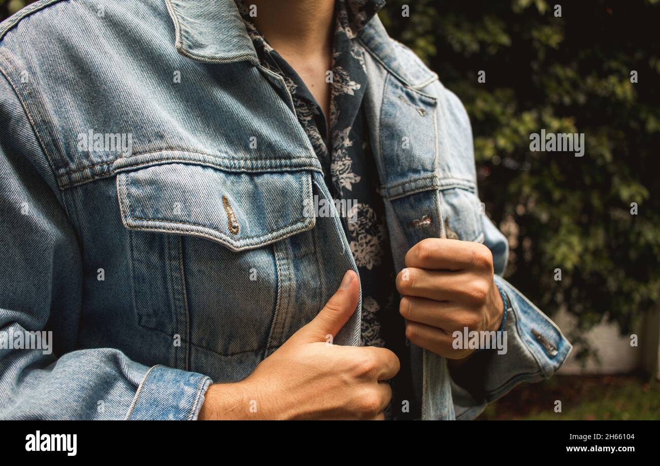 Il giovane uomo ispanico jean giacca moda con elegante camicia bottoni-up floreale Foto Stock