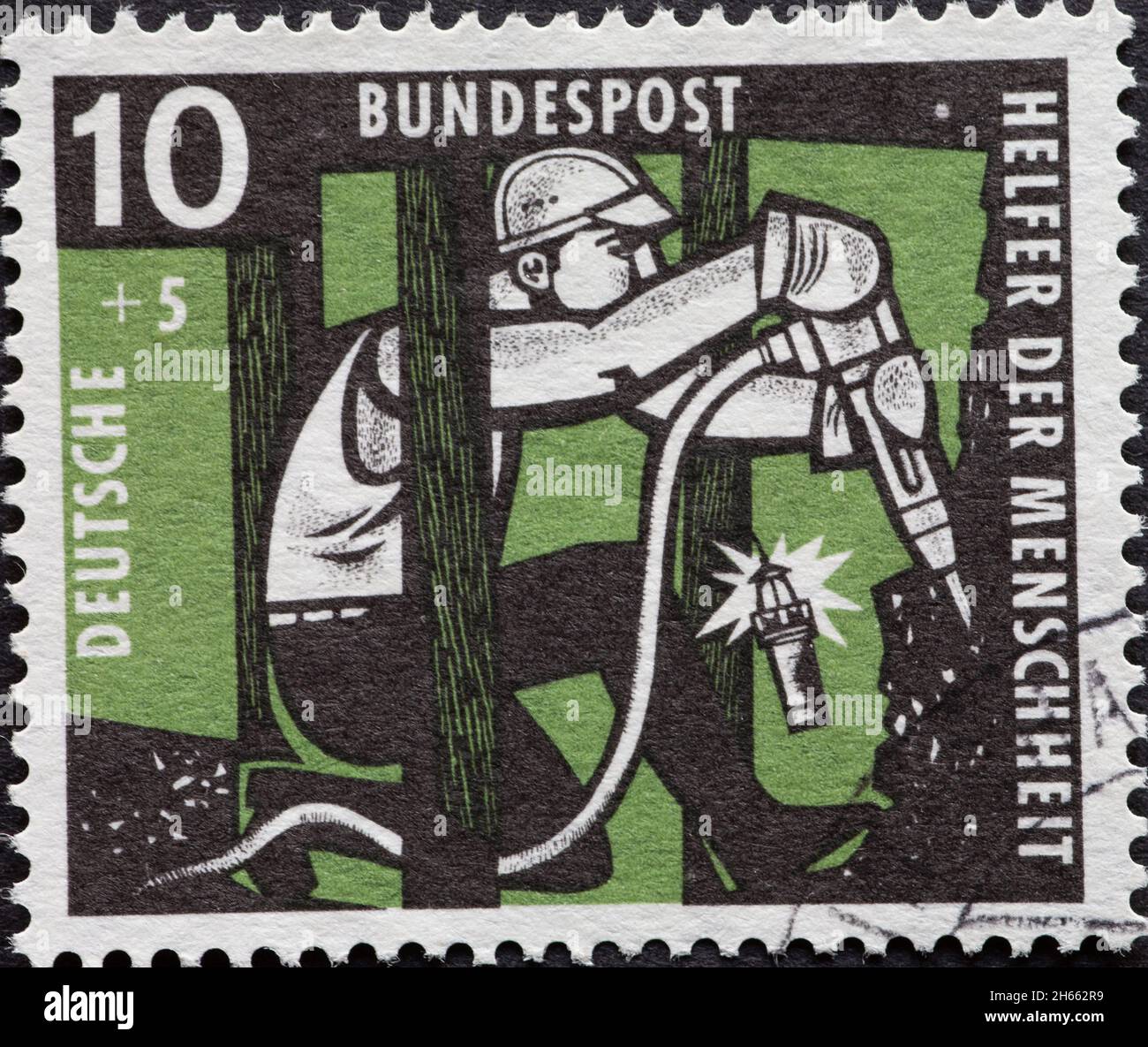GERMANIA - CIRCA 1957: Questo francobollo benefico mostra un minatore con carbone da miniera a martelli. Il colore di sfondo è verde Foto Stock