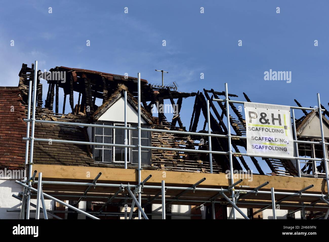 Tetto bruciato con impalcature danneggiate nel fuoco, Alcester, Warwickshire, Regno Unito Foto Stock