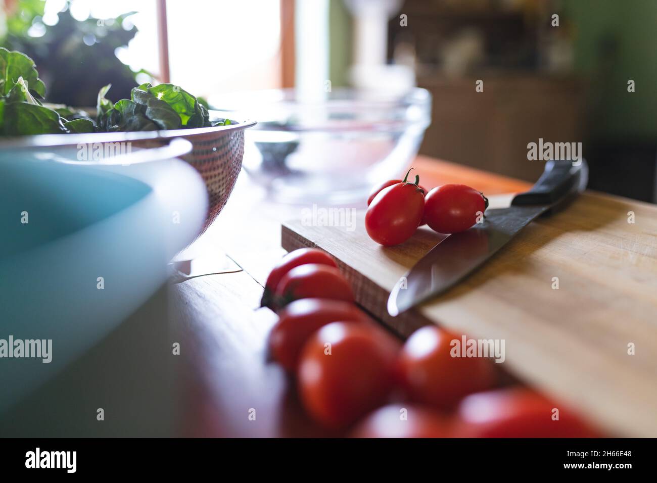 Primo piano di pomodori rossi freschi con coltello su tagliere in legno in cucina Foto Stock