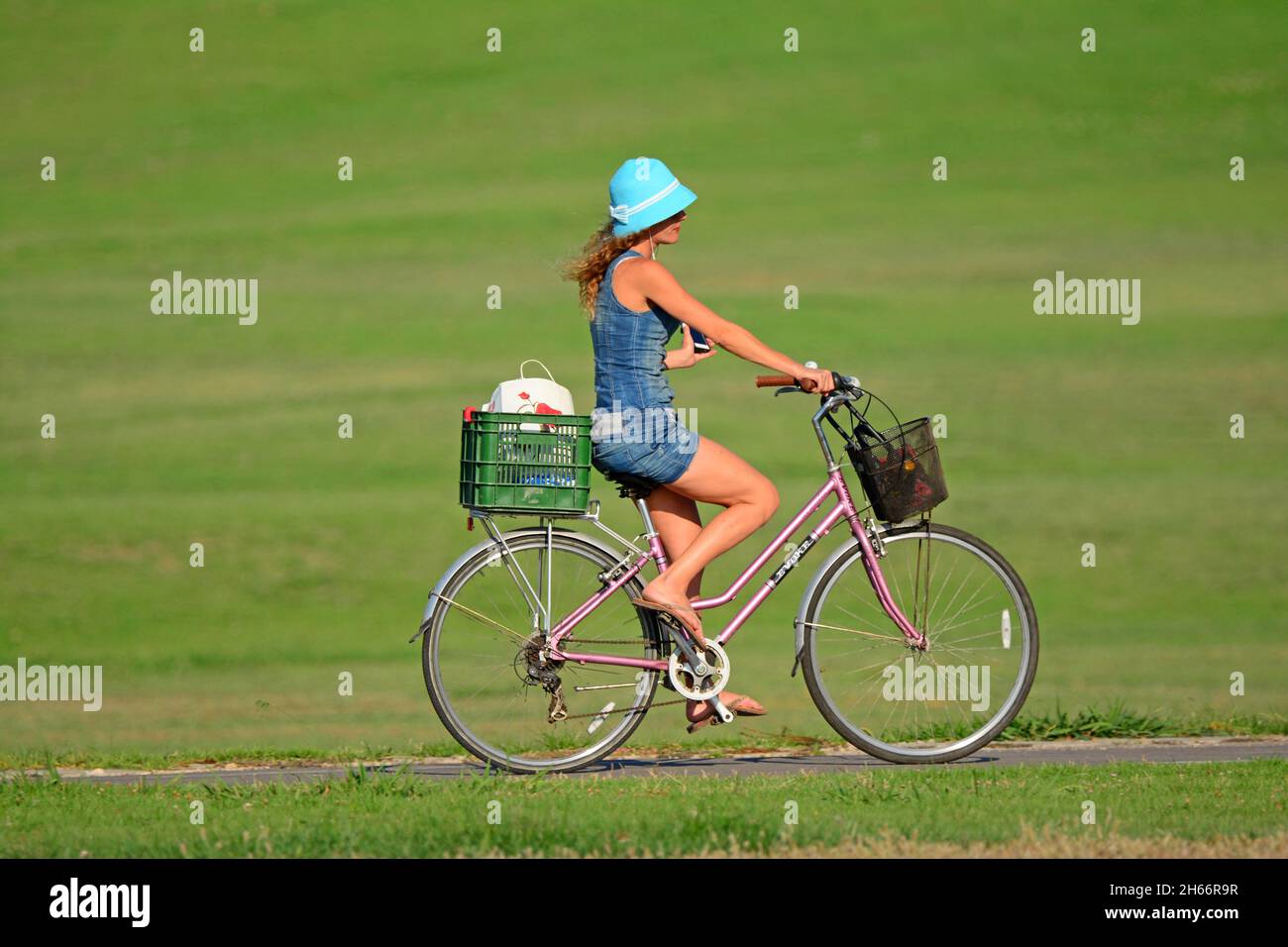 Donna ride una bicicletta nel parco Foto Stock