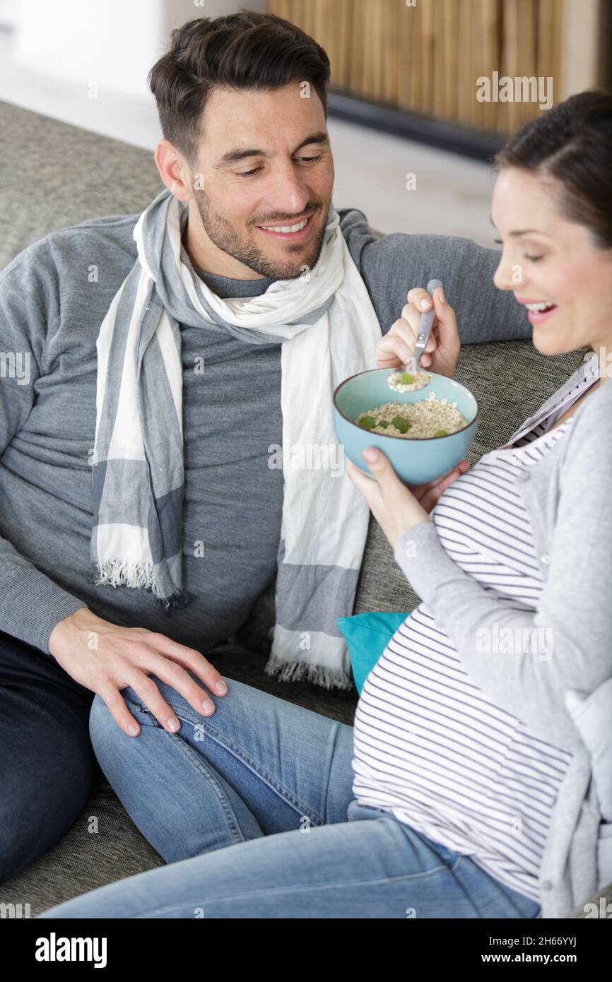 donna incinta che mangia accanto al ragazzo Foto Stock