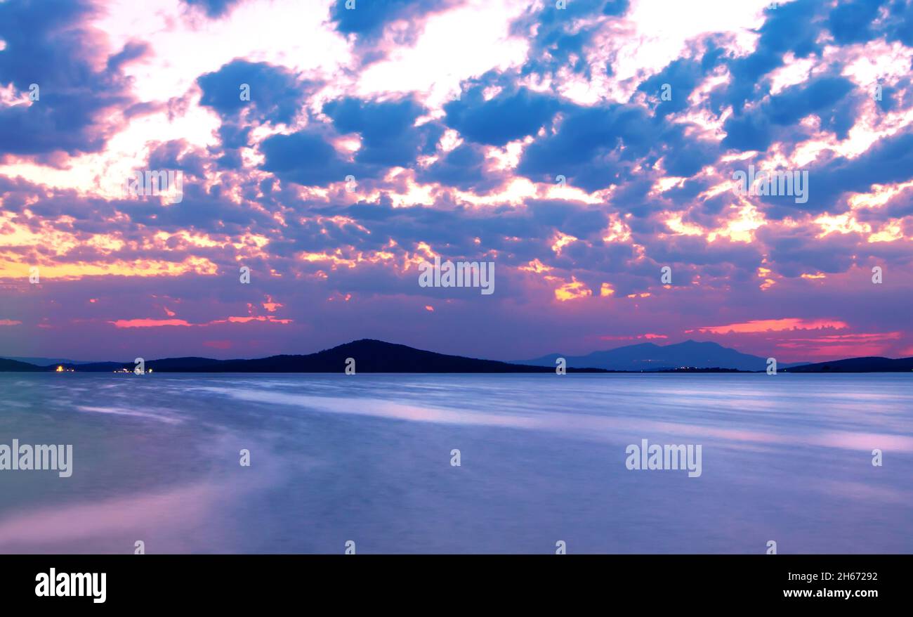 Foto a lunga esposizione di paesaggi marini e nuvolosi dalla costa di Ayvalik dopo il tramonto. Foto Stock