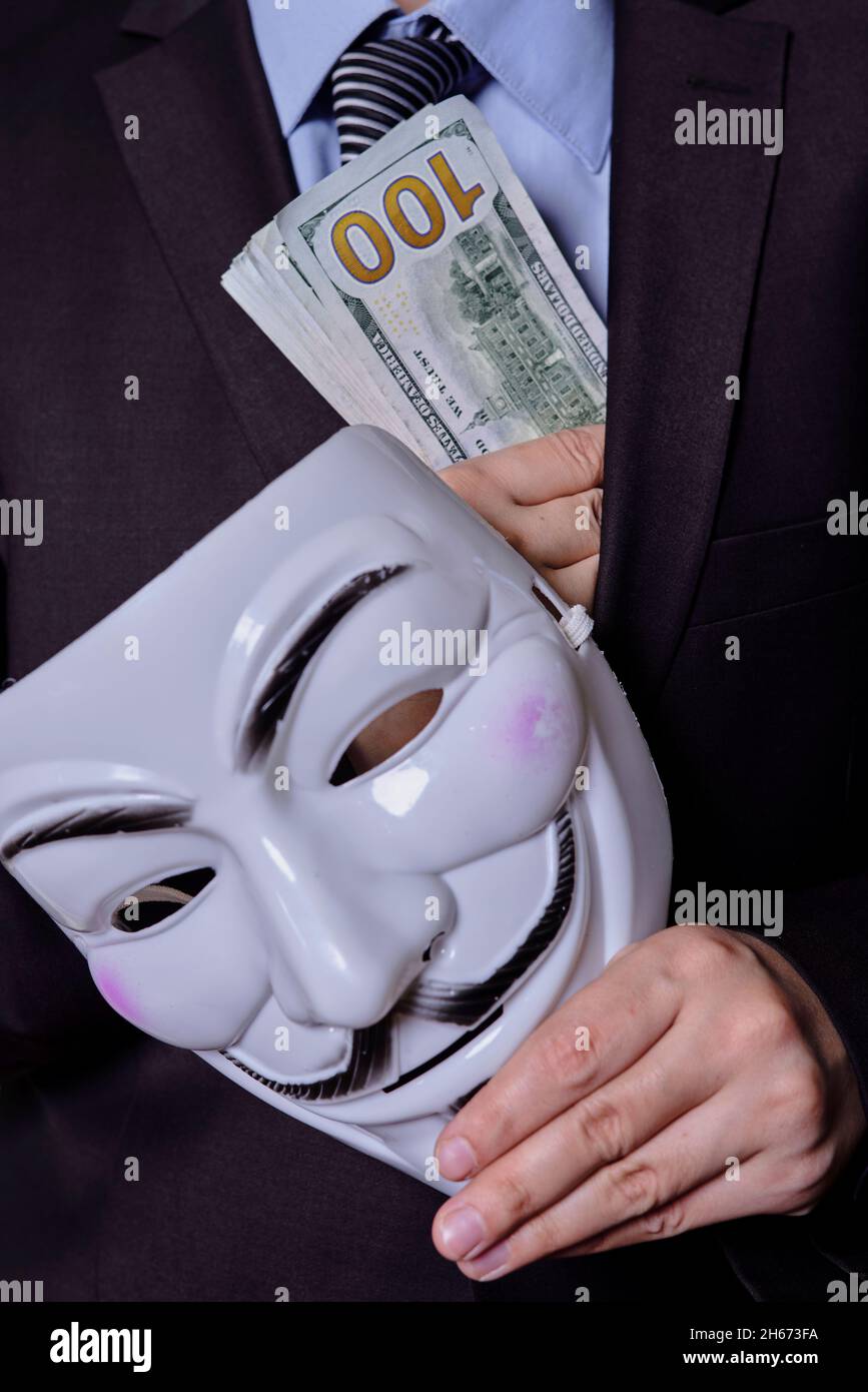 Una persona misteriosa in abbigliamento formale contiene una maschera  anonima e un mucchio di dollari. Dare una tangente, corruzione, dare denaro  ai concetti politici Foto stock - Alamy