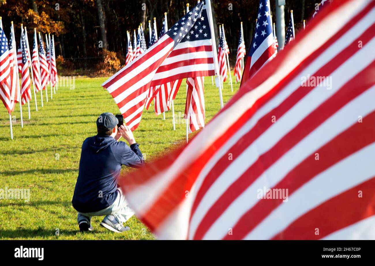 Un uomo fotografa al Dennis (Cape Cod, Massachusetts), campo d'onore. Un giorno dei Veterans salutano coloro che hanno servito. 400 bandiere statunitensi sponsorizzate Foto Stock