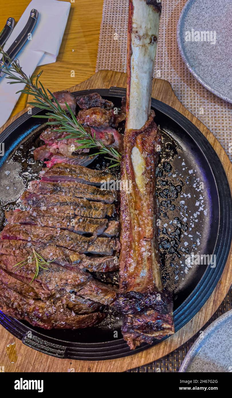 Delizioso angus tomahawk grigliato affettato e stagionato pronto per essere mangiato Foto Stock