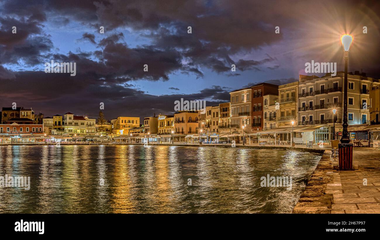 Vecchio porto veneziano di Chania di notte con riflessi colorati nella baia da una lampada di strada incandescente, Chania, Creta, Grecia, ottobre 13, 2021 Foto Stock