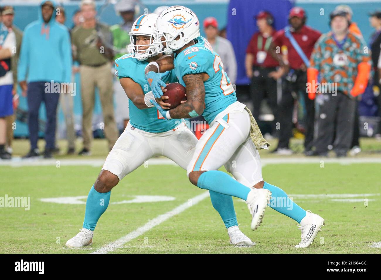 Giovedì 11 novembre 2021; Miami Gardens, Florida USA; Miami Dolphins quarterback Tava Tagovailoa (1) passa via la palla a correre indietro Salvon Ahmed (26 Foto Stock