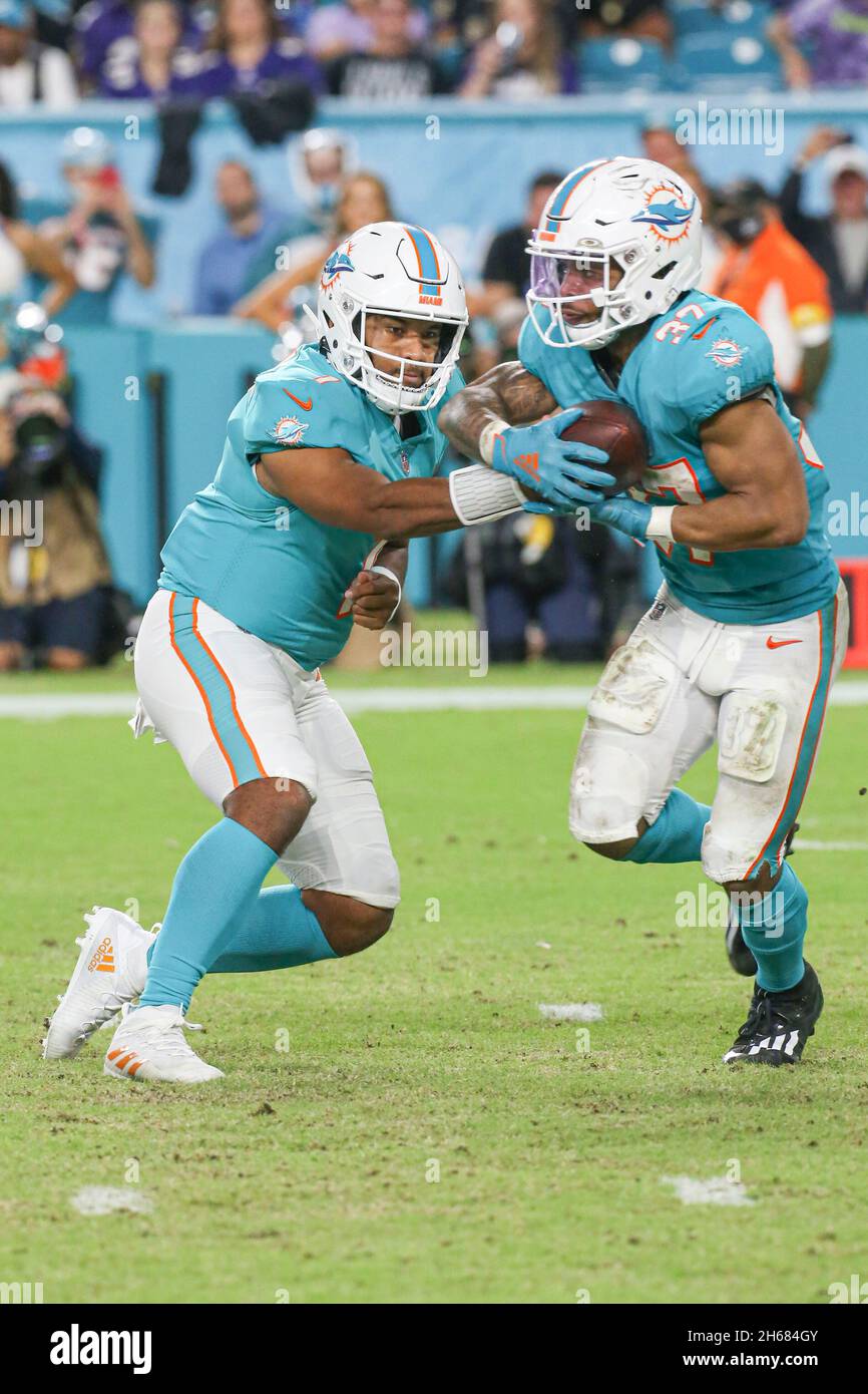 Giovedì 11 novembre 2021; Miami Gardens, Florida USA; Miami Dolphins quarterback Tusa Tagovailoa (1) passa via la palla a running back Myles Gaskin (37 Foto Stock