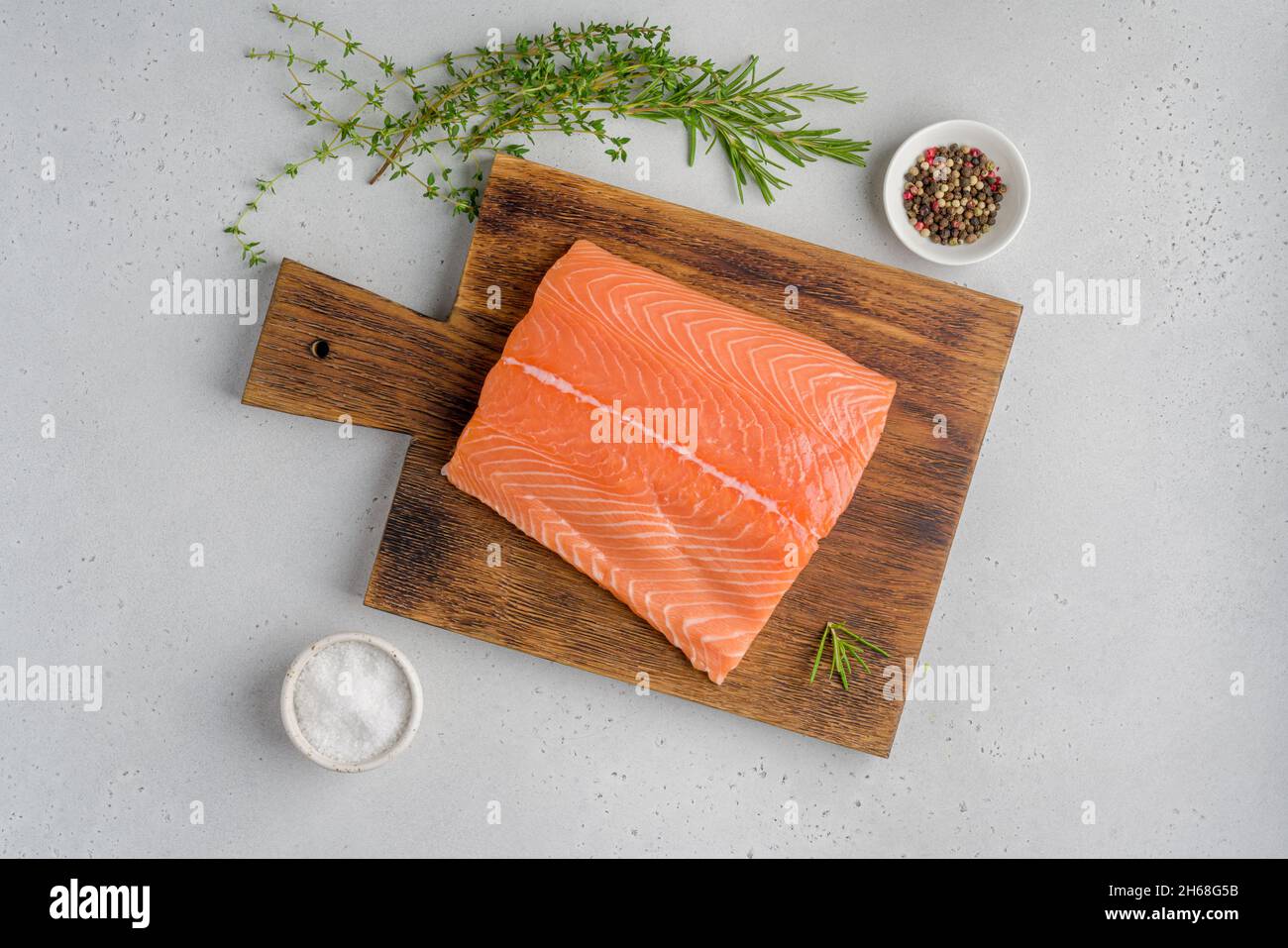 Filetto di salmone scandinavo fresco e crudo. Rosmarino e timo. Omega3 vitamina. Su vecchio asse di legno. Pesce pescetariano per cucinare. Preparazione nutrizione Foto Stock