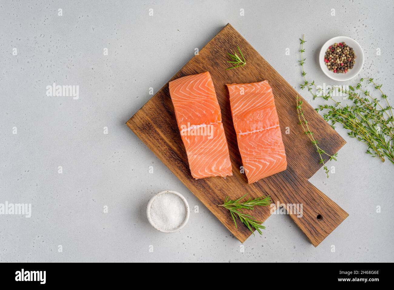 Filetto di salmone scandinavo fresco e crudo. Rosmarino e timo. Sale e pepe. Su vecchio asse di legno. Pesce pescetariano per cucinare. Preparazione nutrizione Foto Stock