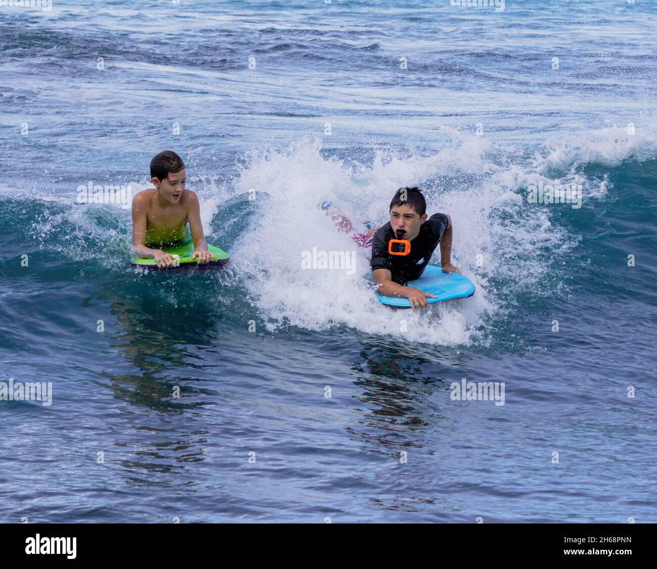 Honolulu, Hawaii - 6 novembre 2021 i ragazzi giovani giocano sulle loro tavole boogey nel surf. Foto Stock