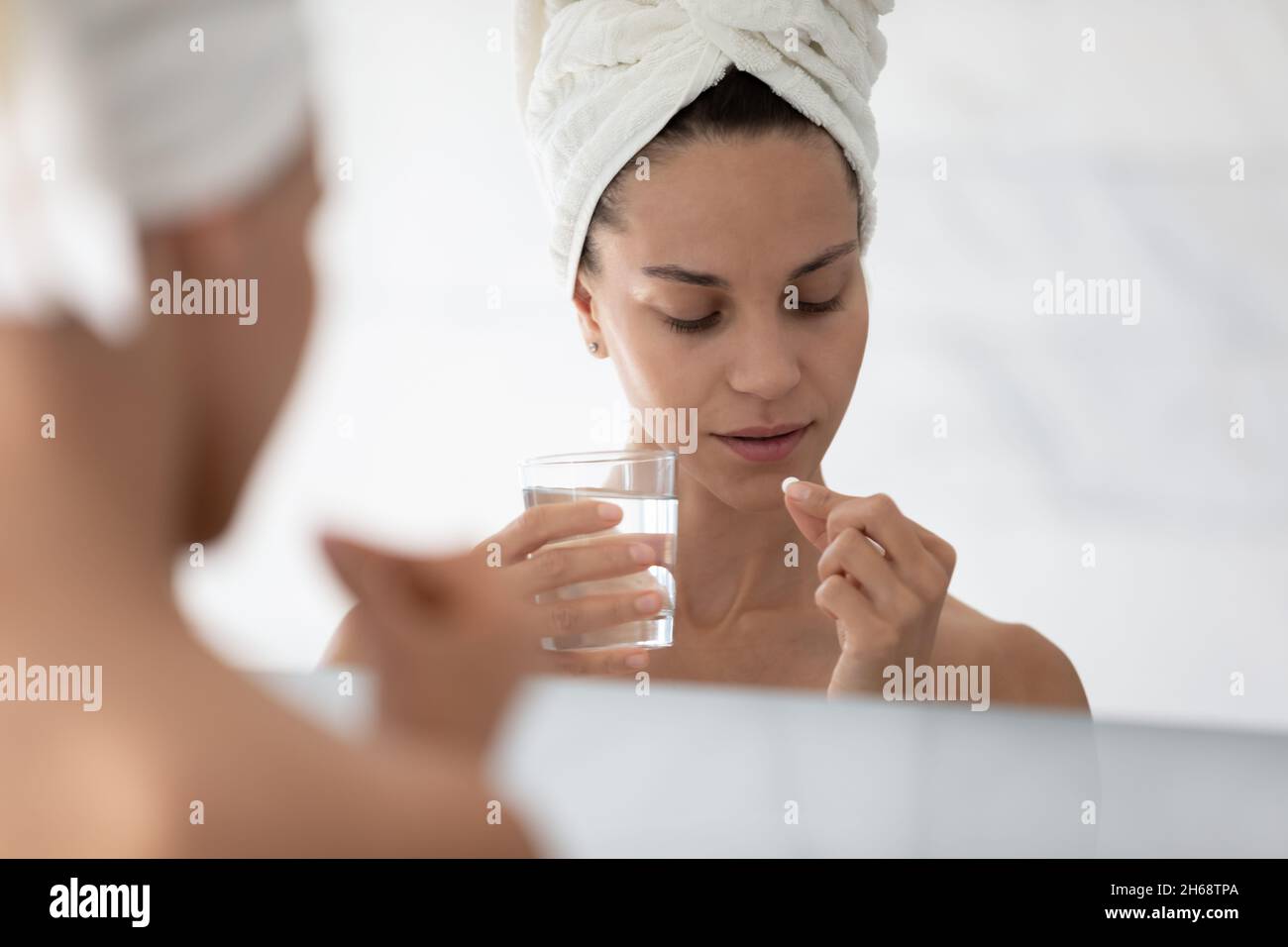 Felice giovane ispanica mista donna corsa prendendo vitamine giornaliere. Foto Stock