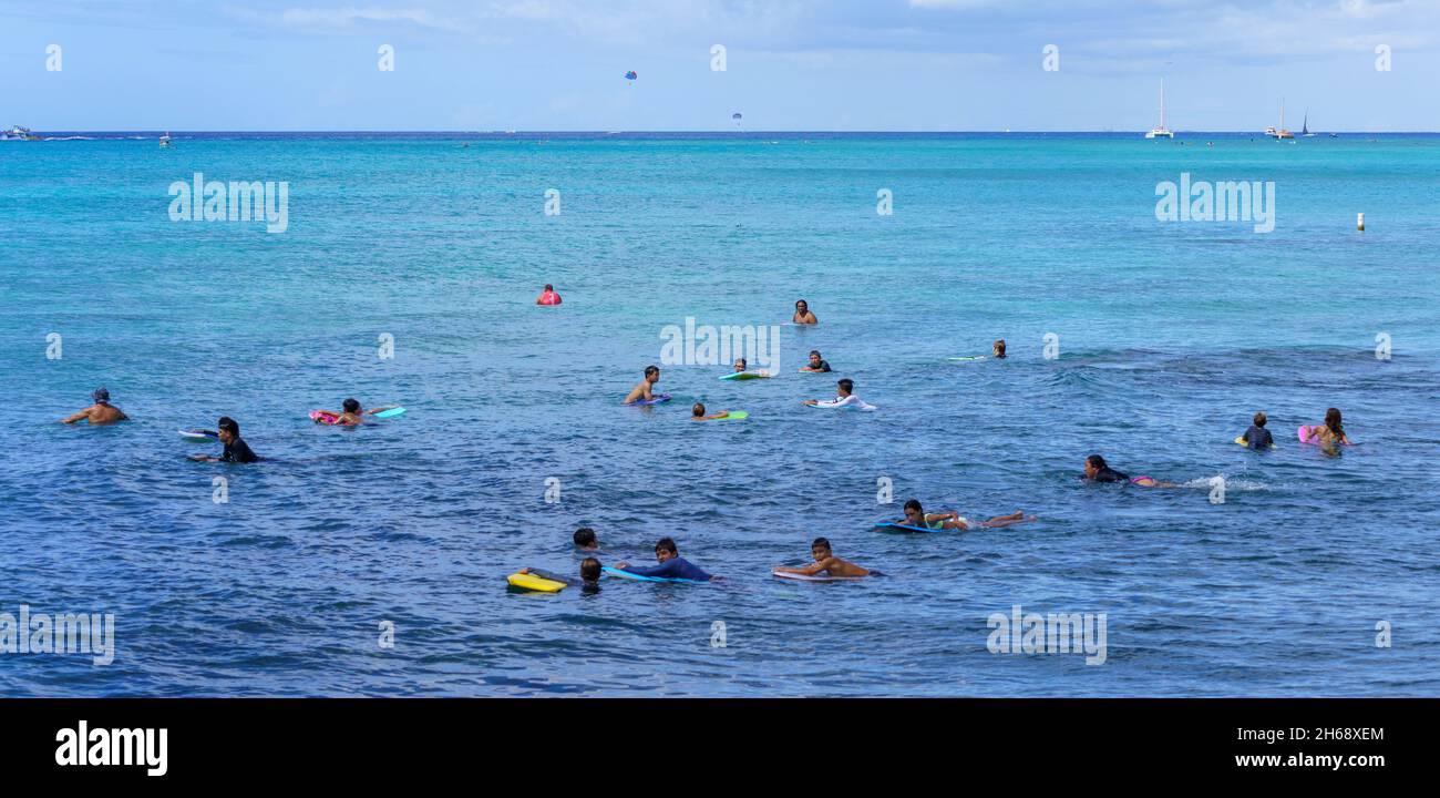 Honolulu, Hawaii - 6 novembre 2021-i giovani aspettano con le loro tavole boogey per la prossima onda di surf. Foto Stock