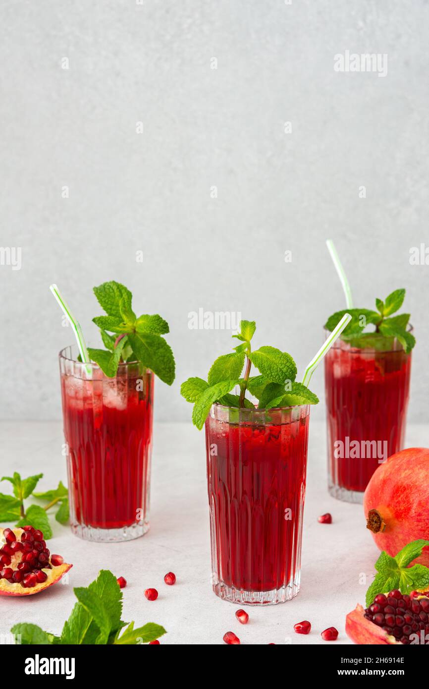 Rinfrescante succo di melograno in bicchieri con paglia di menta e vetro, bevanda fredda Foto Stock