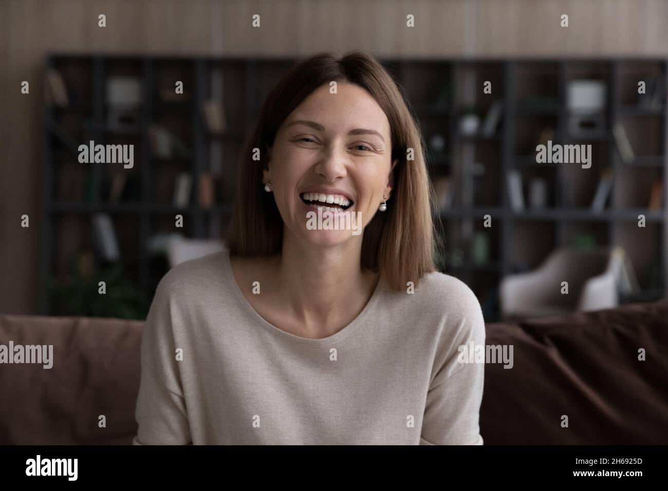 Ritratto della testa di una donna sorridente emozionata che guarda la fotocamera Foto Stock