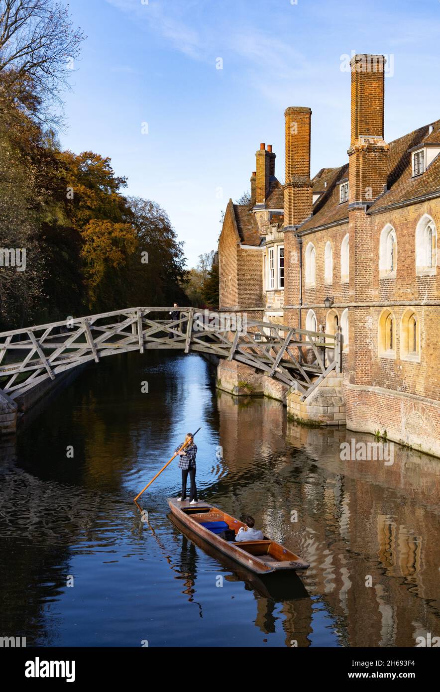 Punting Cambridge UK; una donna che punisce sotto il ponte matematico di Isaac Newton in autunno, Queens College Cambridge University, Cambridge Inghilterra Foto Stock