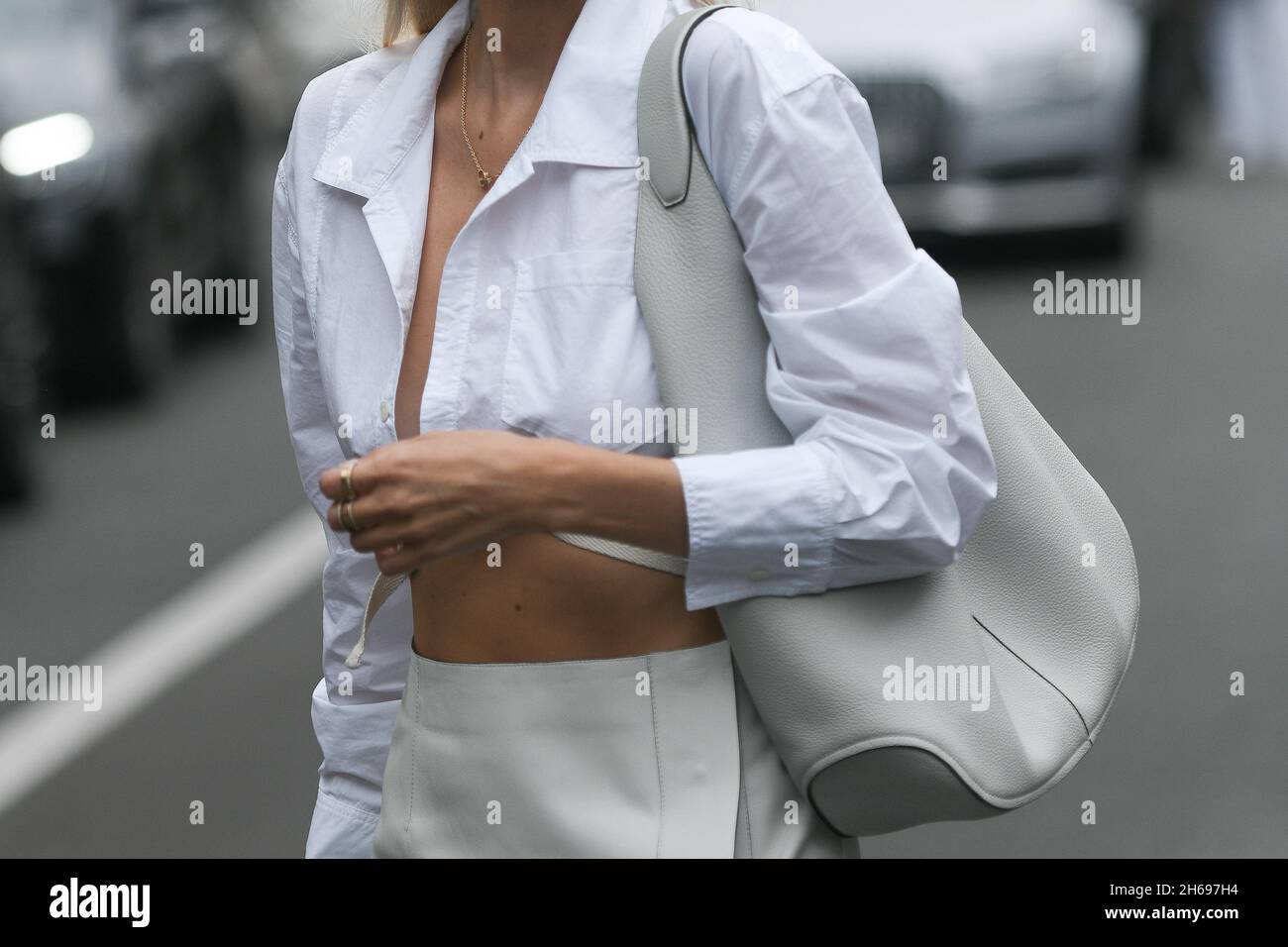 Milano, Italia - 24 settembre 2021: Abito Street style, donna alla moda che indossa una gonna lunga divisa in pelle lucida grigio chiaro, una lea in grana grigio chiaro Foto Stock