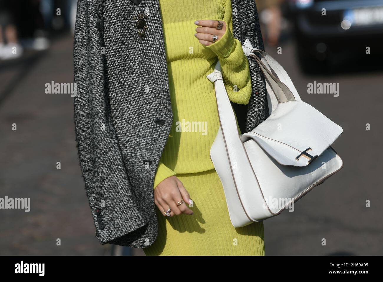 Milano, Italia - 24 settembre 2021: Vestito Street style, donna alla moda che indossa un abito giallo dolcevita, blazer grigio, borsa bianca per le strade di mi Foto Stock