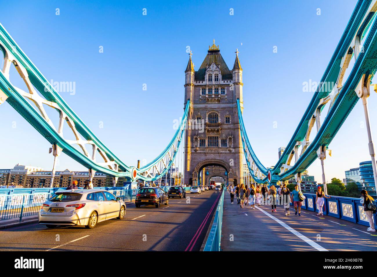 Auto e piedistallo che attraversano Tower Bridge sul Tamigi la sera, Londra, Regno Unito Foto Stock