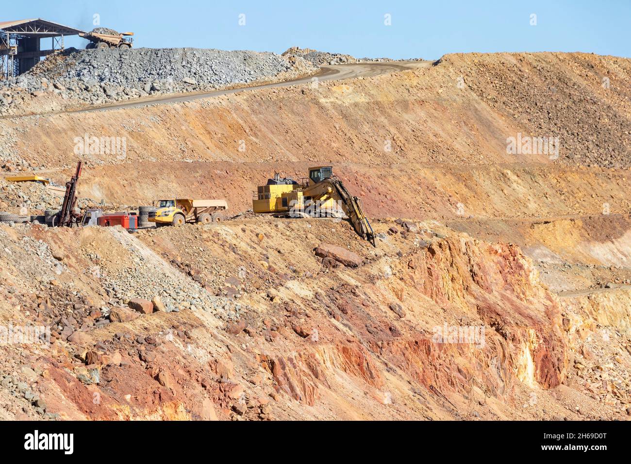 Camion e macchinari minerari a Corta Atalaya miniera aperta buca. Scavi profondi di pirite ed estrazione di minerali di cooper e oro in comune di Foto Stock