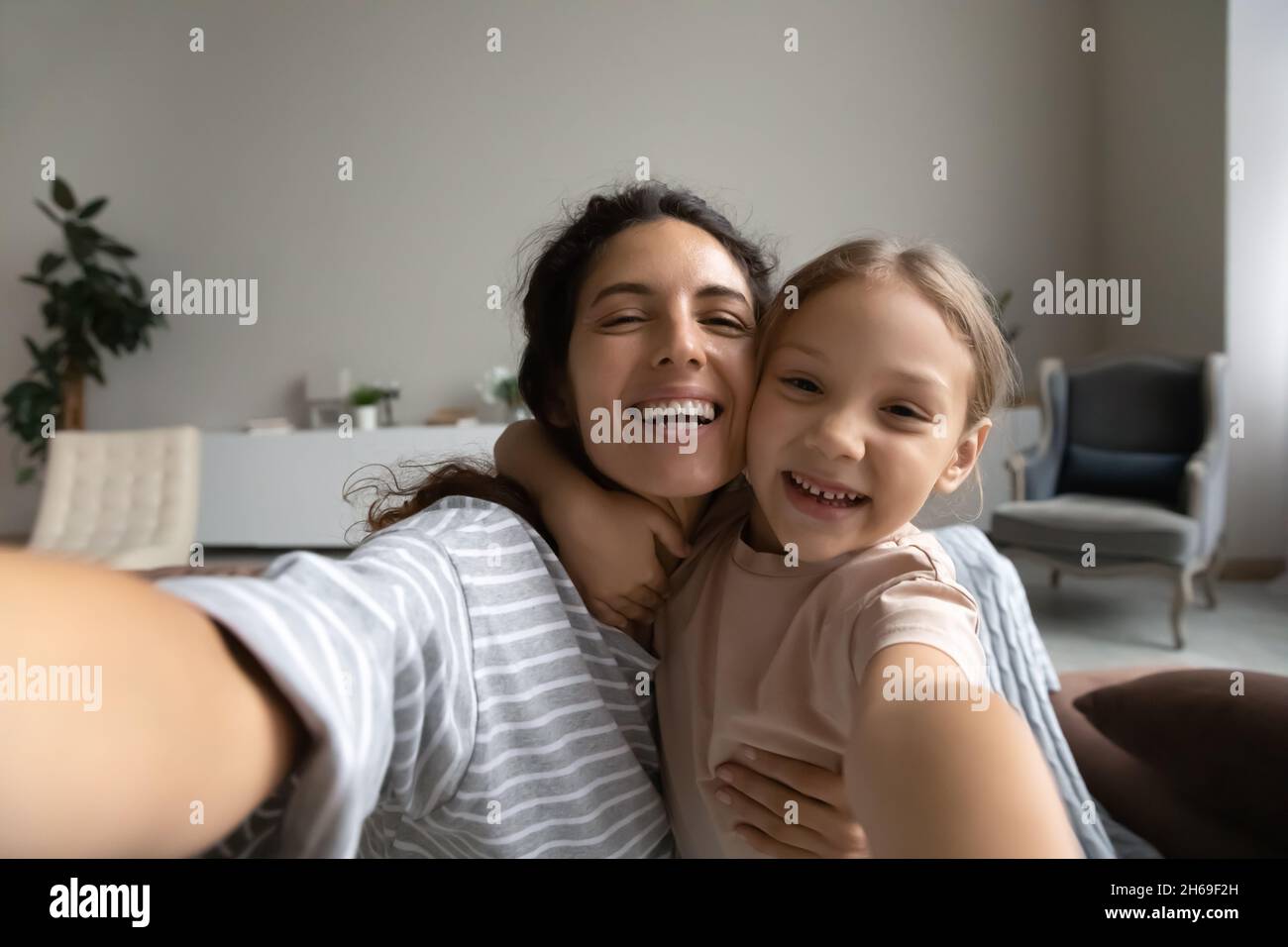 Testa ritratto girato di madre sorridente e figlia prendendo selfie Foto Stock