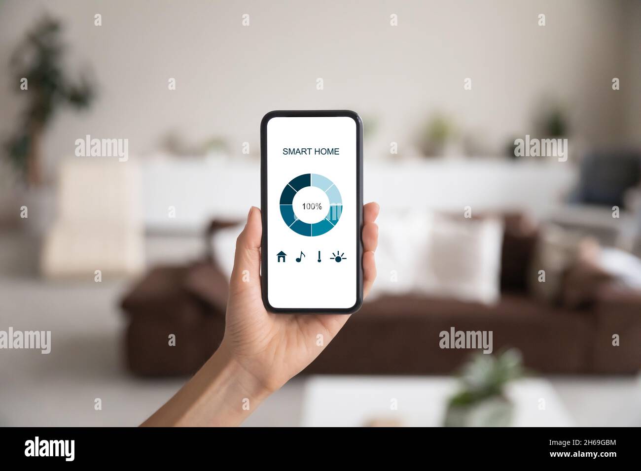 Primo piano smartphone in mano femminile, interfaccia sistema smart home Foto Stock