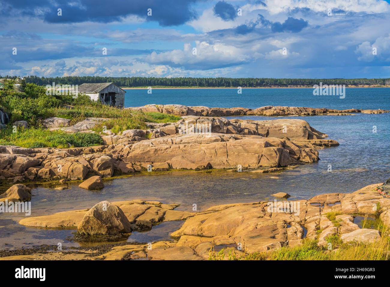 La costa rocciosa del fiume San Lorenzo alla fine di un pomeriggio estivo a Kegaska, un piccolo villaggio di pescatori alla fine della strada panoramica 138, in C. Foto Stock