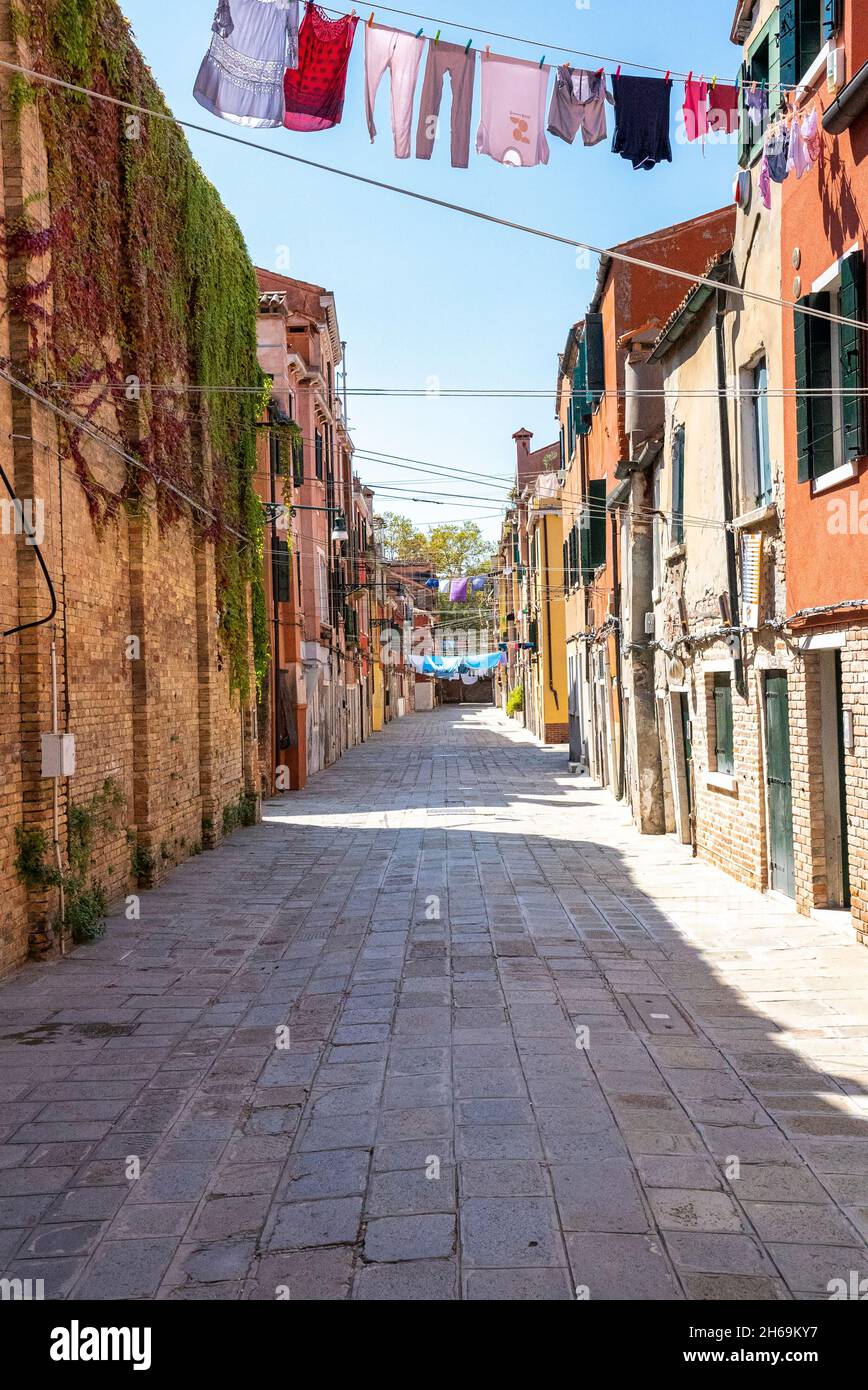 Sentiero di uno stretto vicolo residenziale con vestiti appesi per asciugare su clothesline Foto Stock