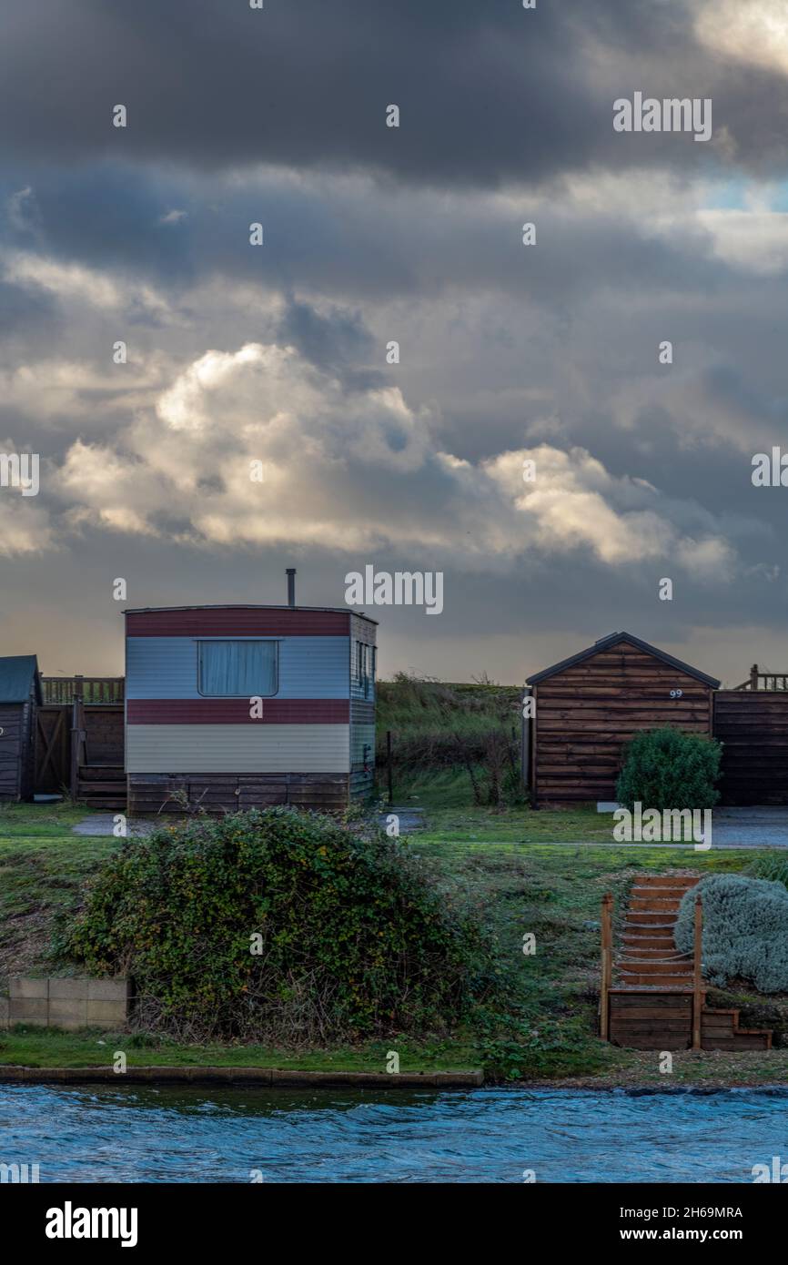 capanne sulla spiaggia a snettisham sulla costa di norfolk, immagine di moody di capanne sulla spiaggia con spazio per la copia, cieli tempestosi sopra capanne sulla spiaggia di norfolk. Foto Stock