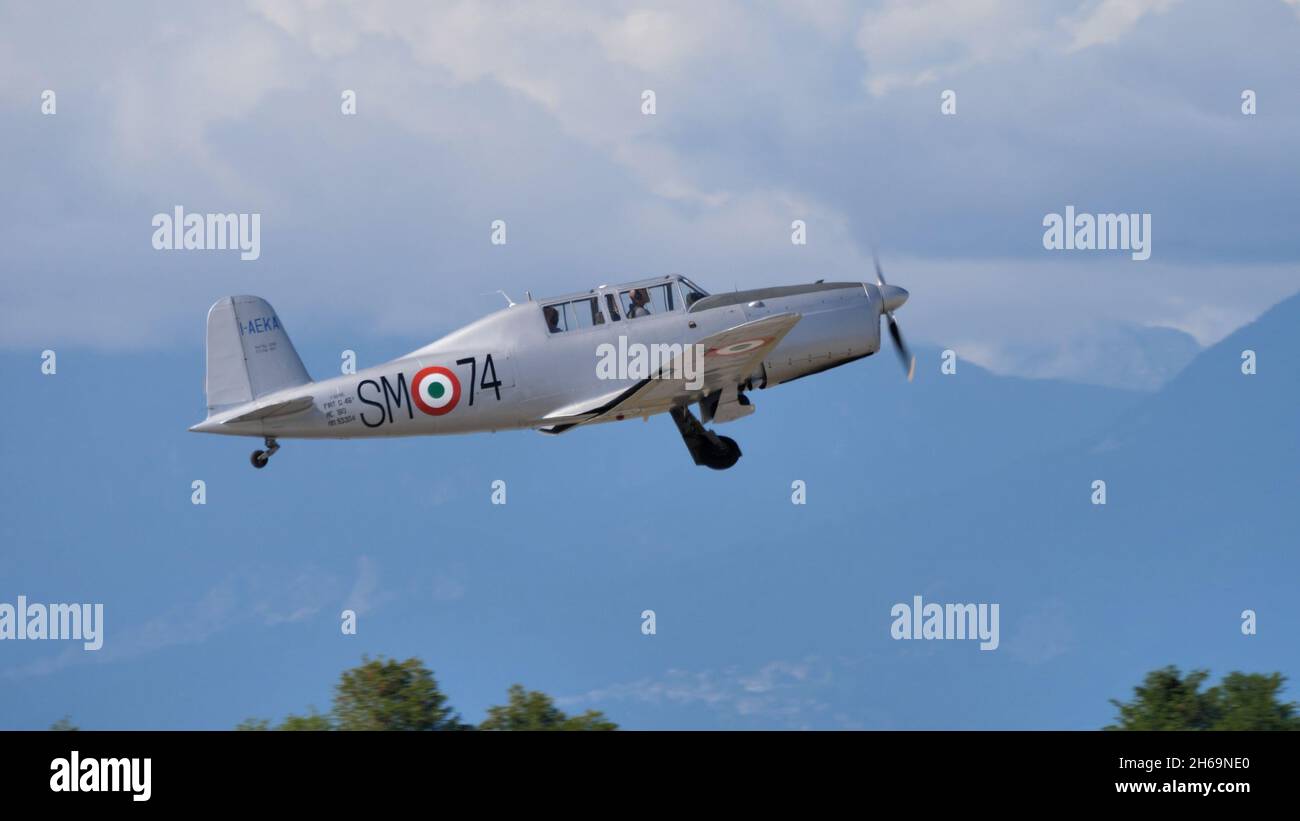 Rivolta del Friuli, Udine, Italia SETTEMBRE, 17, 2021 grigio metallo due posti in aereo militare tandem d'epoca ritraggono il carro dopo decollo con montagne sullo sfondo. Fiat G.46 Foto Stock