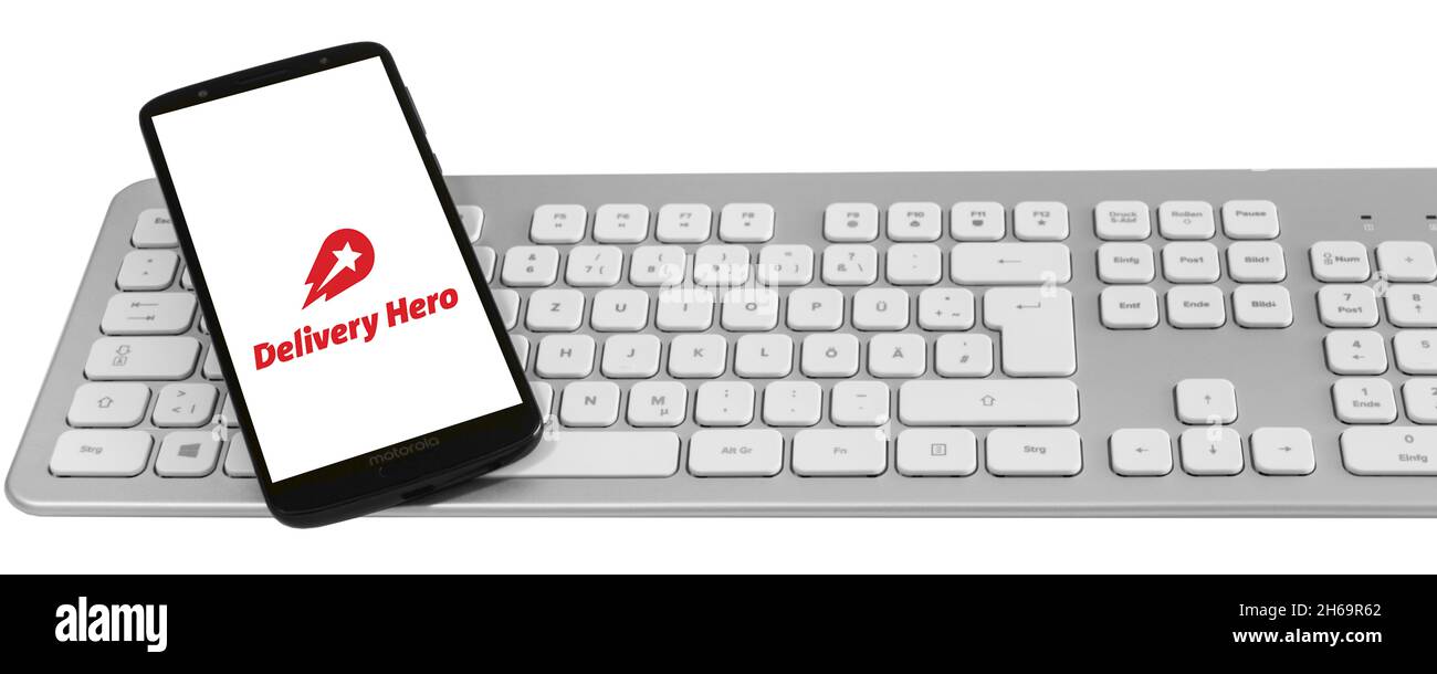 Amburgo, Germania - Novembre 14 2021: Consegna Hero Lieferservice mit Logo smartphone Tastatur Aktienmarkt banner sfondo bianco Foto Stock