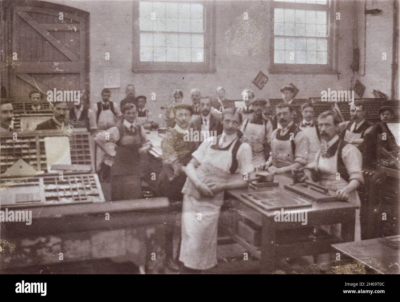 Gli addetti alla stampa che si posano in officina, vassoi di tipo mobile sono visibili sui tavoli, all'inizio del XX secolo Foto Stock