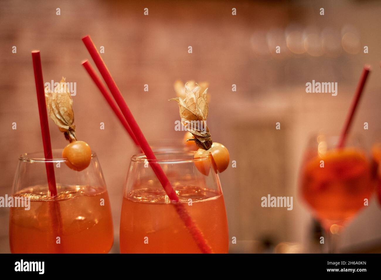 Cocktail alcolico di colore arancione con provette rosse. Lavora come barista in un night club Foto Stock
